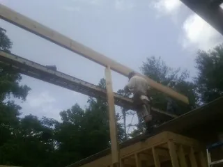 Carpenter setting a ridge beam over a new addition frame — Ice Dam Removal by Roofing Brothers in Lowman